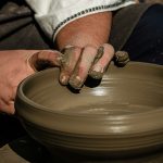 a man is making a bowl on a potter's wheel
